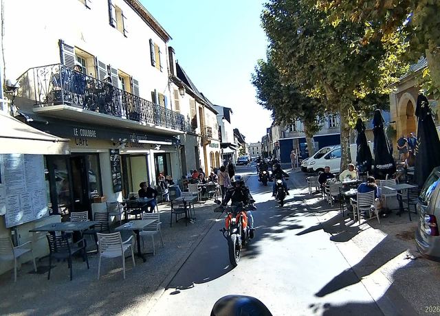 Rue principale d'un bourg périgourdin, moteurs au ralenti.